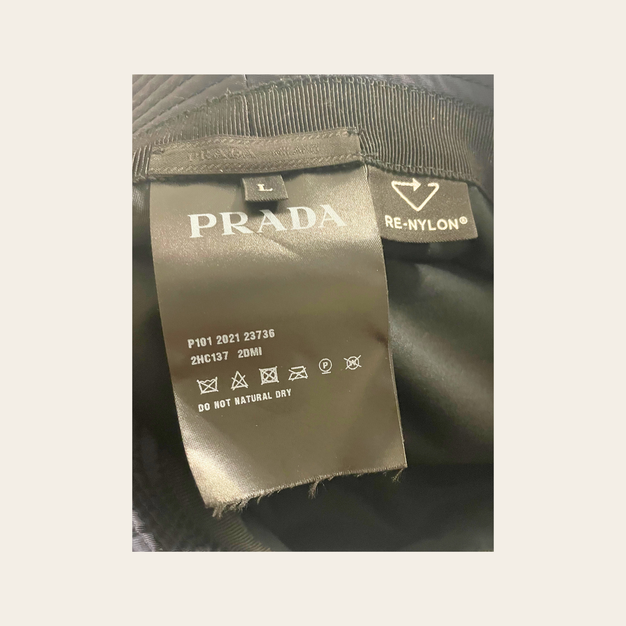 PRADA – Re-Nylon Bucket Hat avec plaque triangulaire émaillée