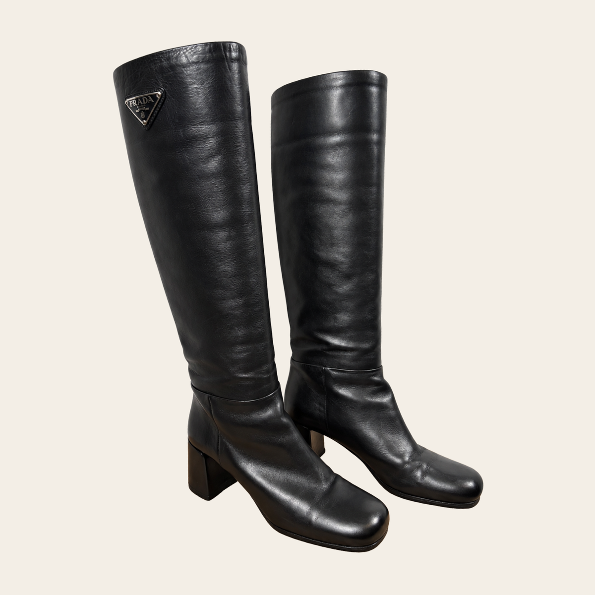 PRADA — Bottes hautes en cuir noir à talons blocs et logo triangulaire émaillé, taille 38