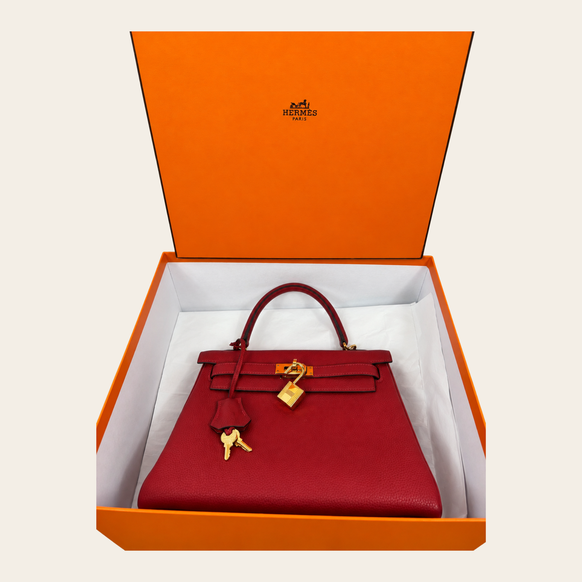 HERMÈS — Kelly 25 Retourne en cuir Togo rouge, quincaillerie dorée