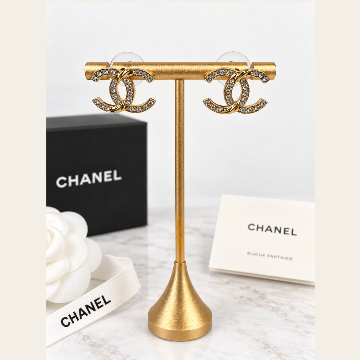 CHANEL — Boucles d’oreilles CC façon fer à cheval en métal doré et cristaux